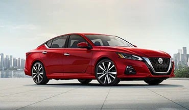 2023 Nissan Altima in red with city in background illustrating last year's 2022 model in Peruzzi Nissan in Fairless Hills PA